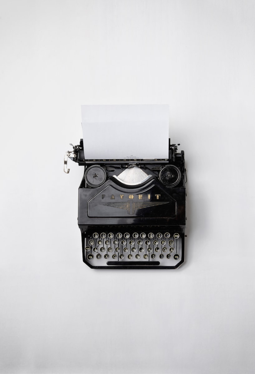 black typewriter with printer paper